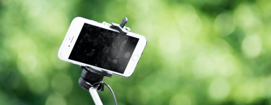 A video marketer uses a selfie stick to create marketing content.