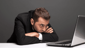 The image depicts a man starting at his computer as he attempts to try marketing on his own. At Marketing Nice Guys, we state 3 things you should consider before any do-it-yourself marketing.