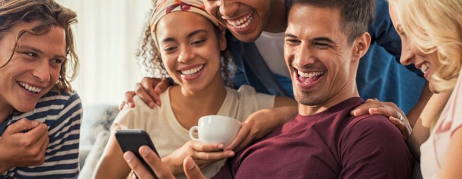 An image that depicts a group laughing at a marketing promotion. Using humor in marketing can be a strategic tool to gain more attention as a small business.
