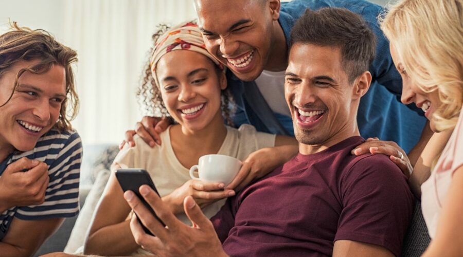 An image that depicts a group laughing at a marketing promotion. Using humor in marketing can be a strategic tool to gain more attention as a small business.